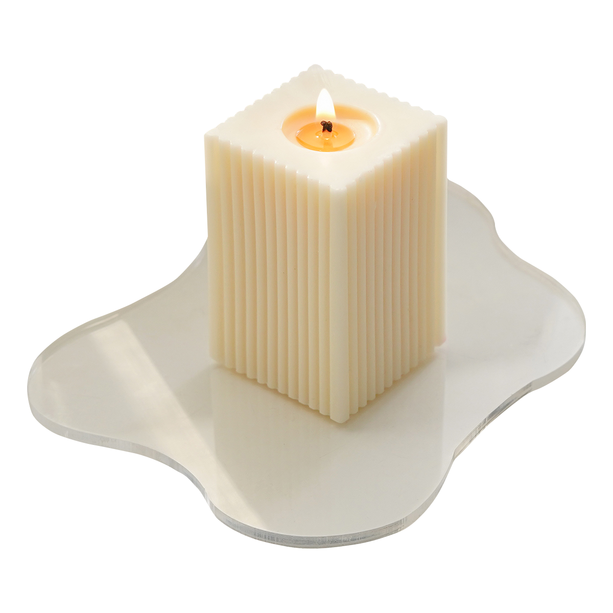 a lit ribbed rectangular soy pillar candle on irregular shape wavy acrylic coaster