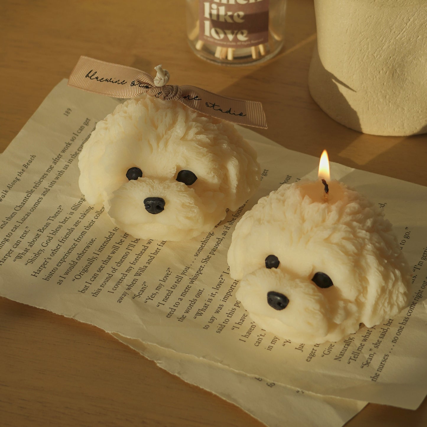 two white bichon candles placed on wooden table