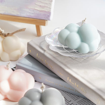 aqua blue cloud soy pillar candle on holographic shell tray on books with pastel cloud candles