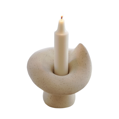 a lit crayon shape soy pillar candle in a ceramic mushroom shape candle holder