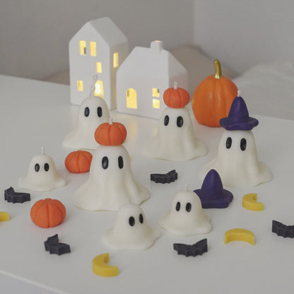 wizard and pumpkin ghost candles with crescent moon, bat, pumpkin wax melts on white table for halloween room decor