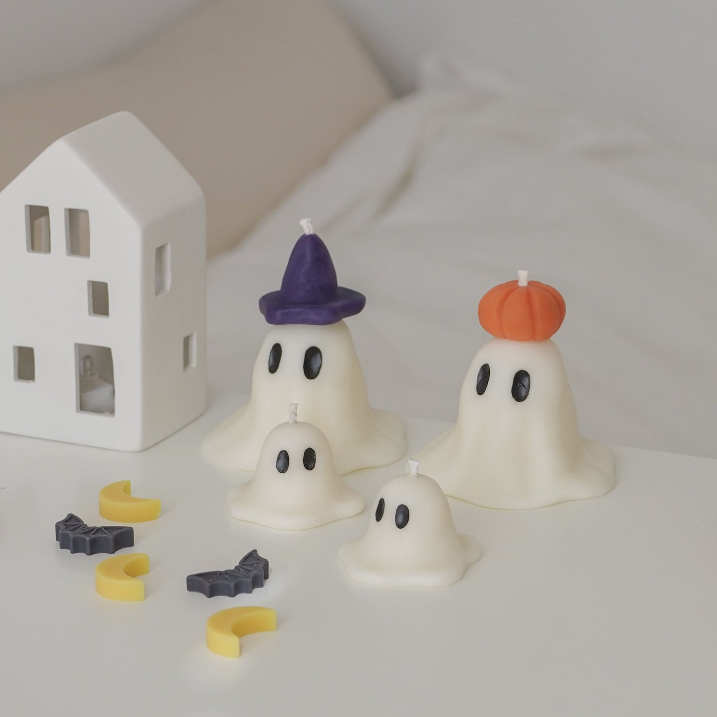 wizard and pumpkin ghost candles with mini ghost candles on white table for halloween room decor