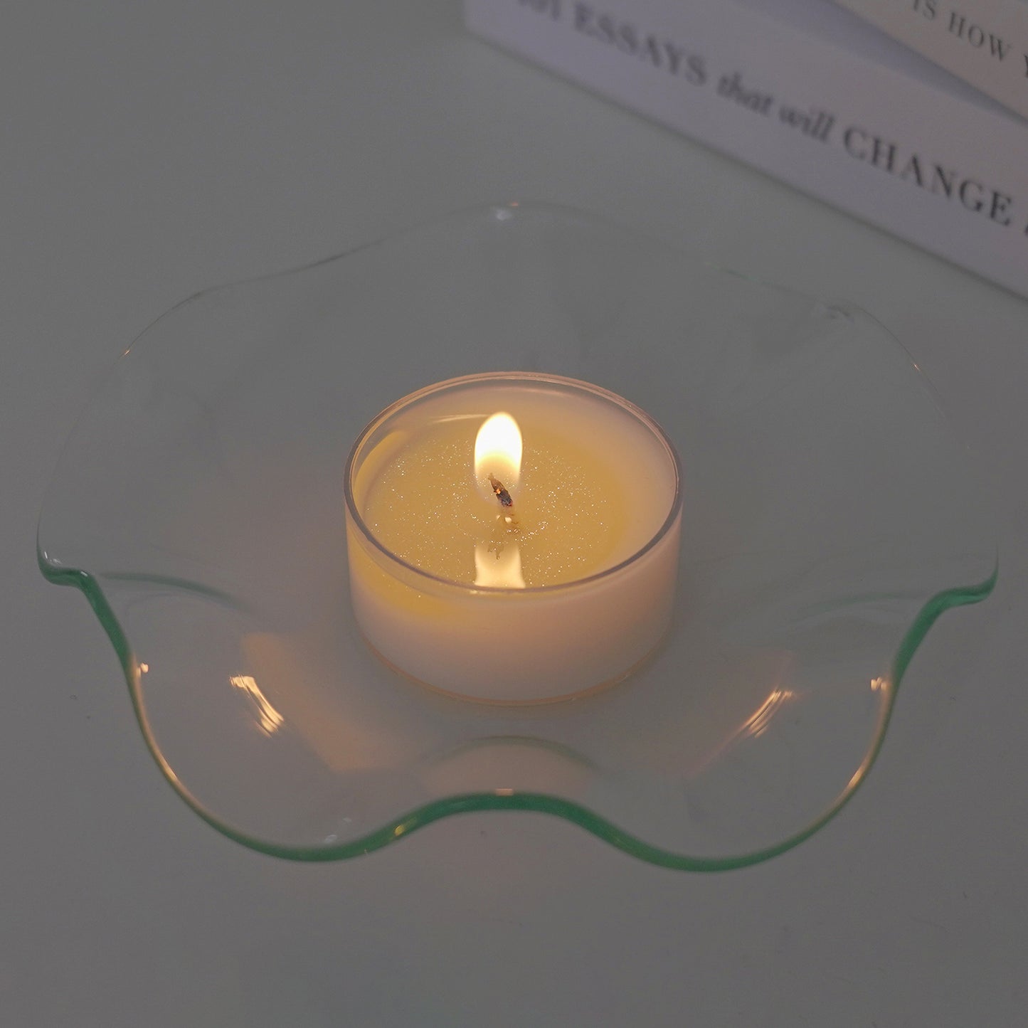 a lit tealight candle on a clear wavy ruffle dish