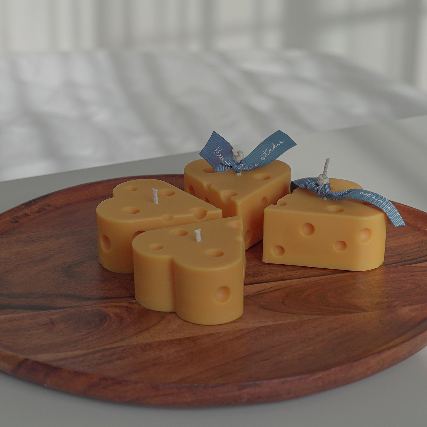 four heart shape cheese candles on wooden tray