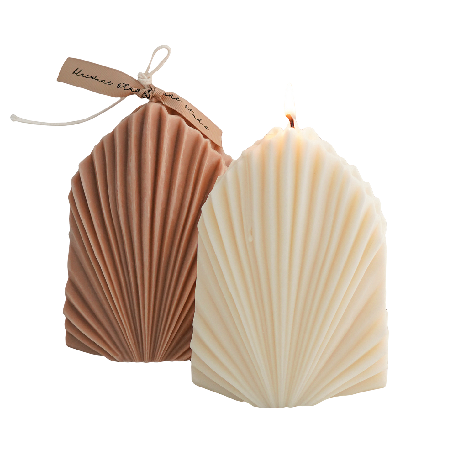 a lit white leaf shape soy pillar candle and beige leaf objet candle