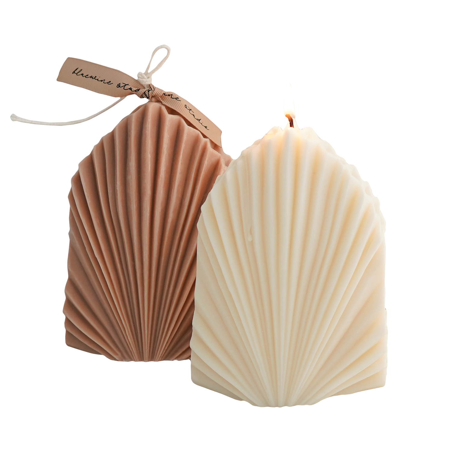 a lit white leaf shape soy pillar candle and beige leaf objet candle