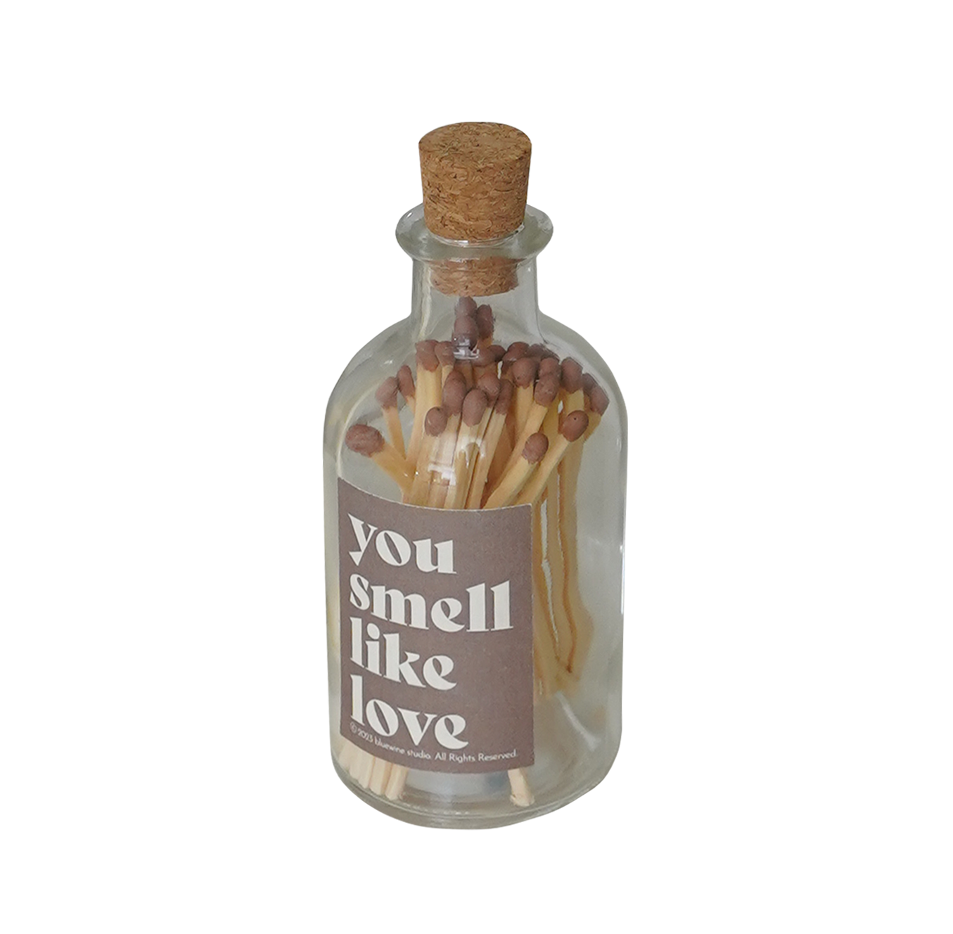 a glass match bottle filled with brown matches and a brown sticker inscribed with "you smell like love"