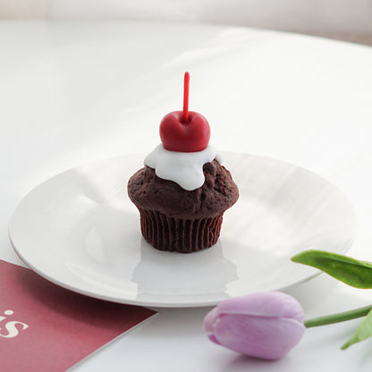 chocolate cherry muffin shape soy pillar candle on a white round plate, lavender tulip, and burgundy paris postcard on white round table