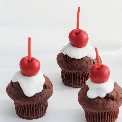 three chocolate cherry muffin shape soy pillar candles on white table