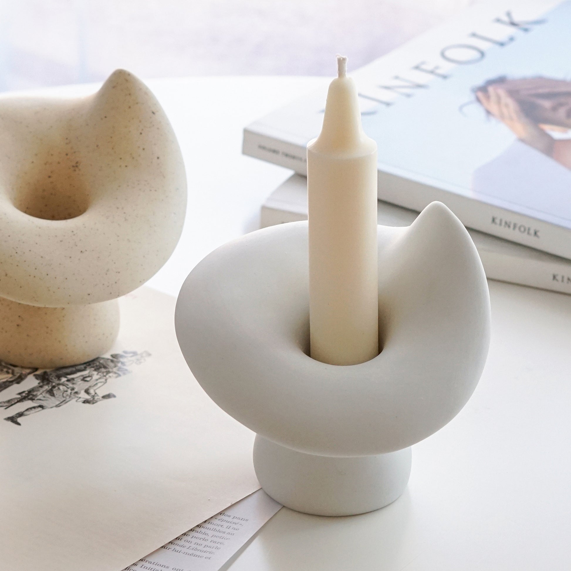 crayon white soy pillar taper candle in a white mushroom ceramic candle holder, a dotted yellow mushroom candle holder, and kinfolk magazines