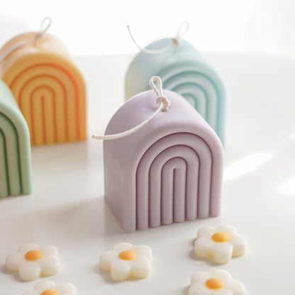 aqua blue, blush pink, lavender, sage green, and tangerine yellow rainbow shape arch pastel color soy pillar candles with long wicks and daisy wax melts