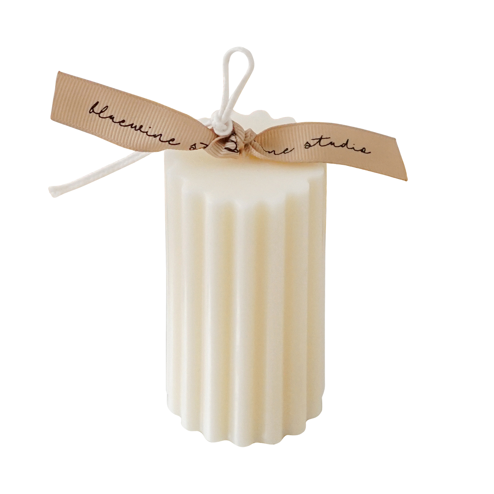 a white fluted ribbed cylinder soy pillar candle with beige bluewine stuio