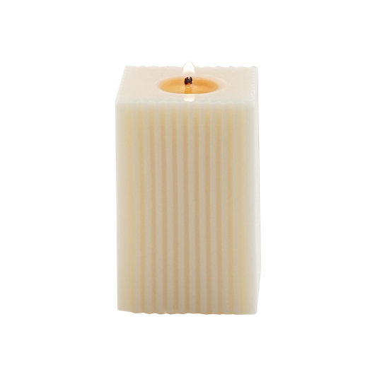 a lit ribbed square pillar candle