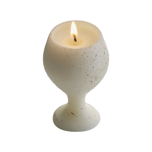 a dotted pattern white soy pillar wine candle burning